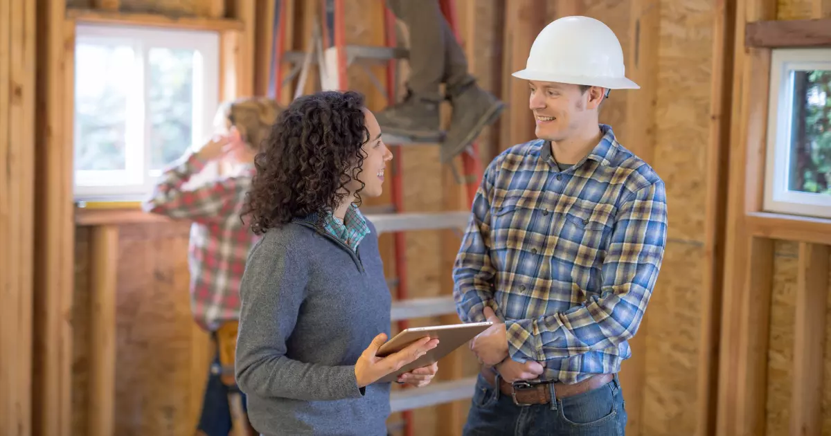 A person and person in hardhats talking