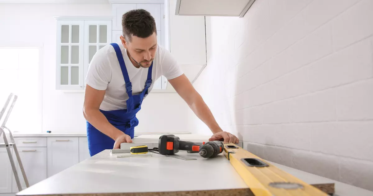 A person in blue overalls using a level on a table