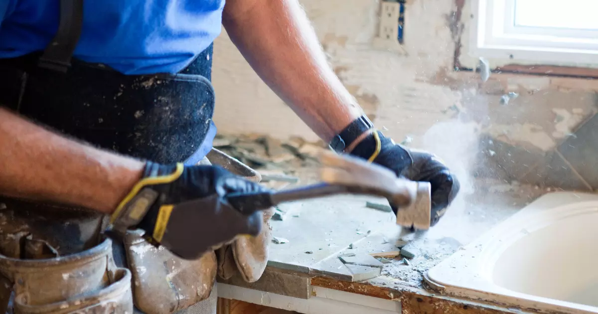 A person holding a hammer for house renovation