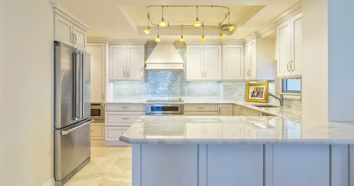 A kitchen with white cabinets and a large island