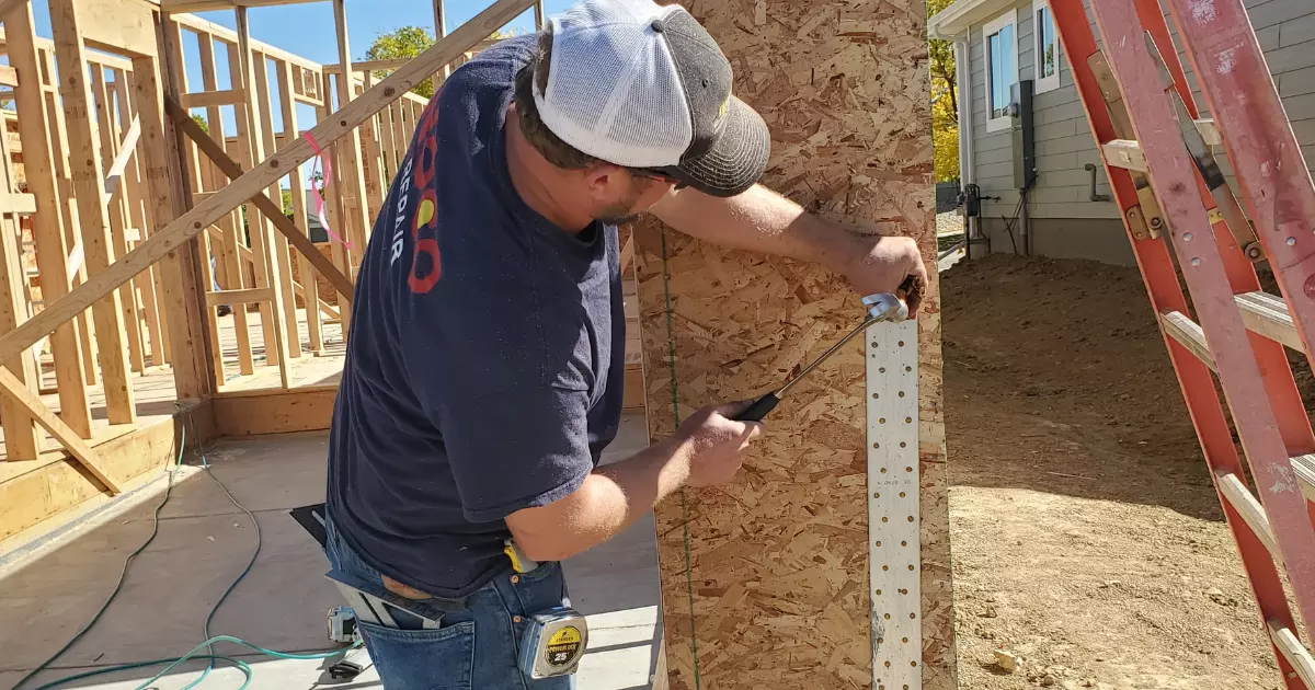 House Addition Contractor hammering a nail on a wood