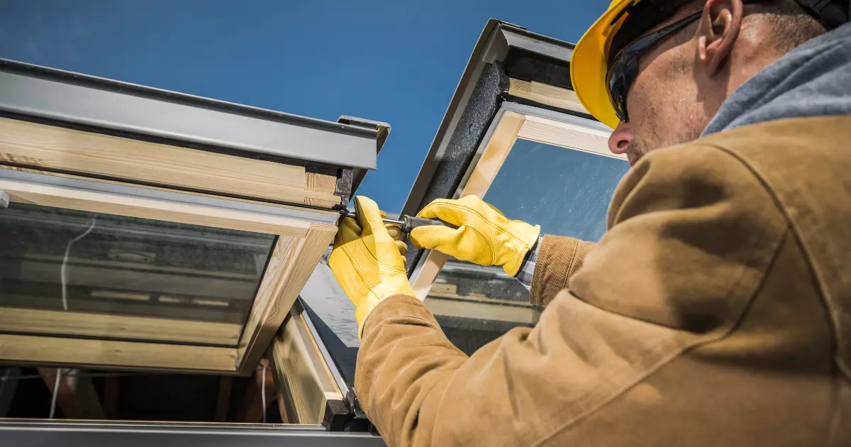 A handyman wearing yellow gloves and holding a screwdriver