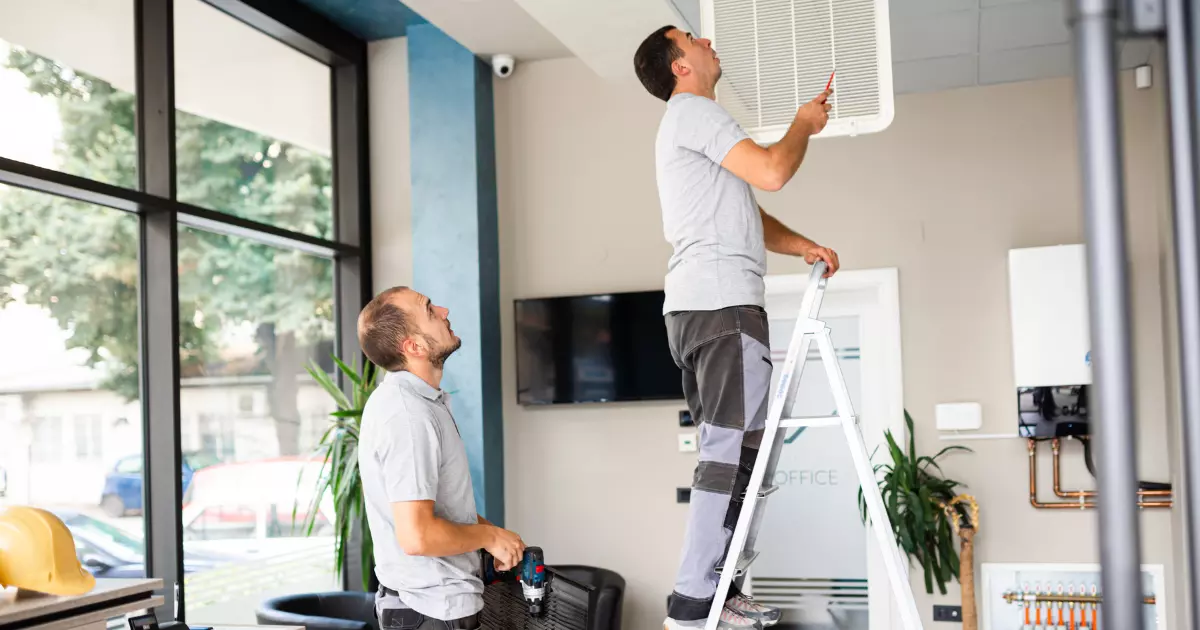 A person on a ladder looking up at another person on a ladder